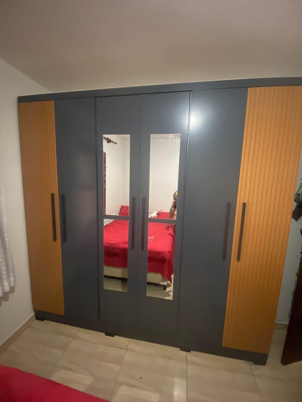 Guarda-roupa grafite de seis portas, com duas portas espelhadas ao centro e laterais ripadas em madeira