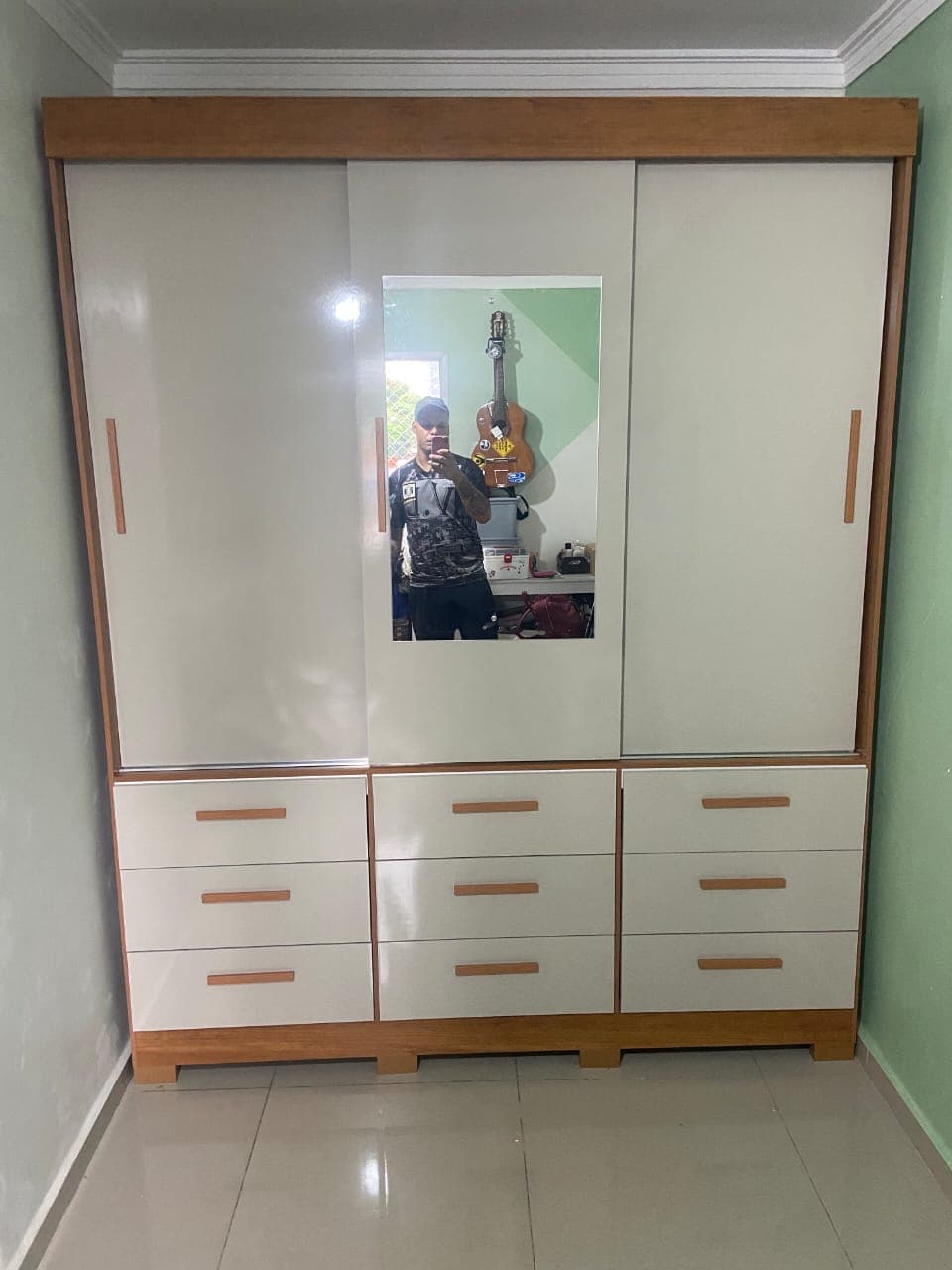 Guarda-roupa de três portas de correr com espelho central e nove gavetas, acabamento branco com madeira